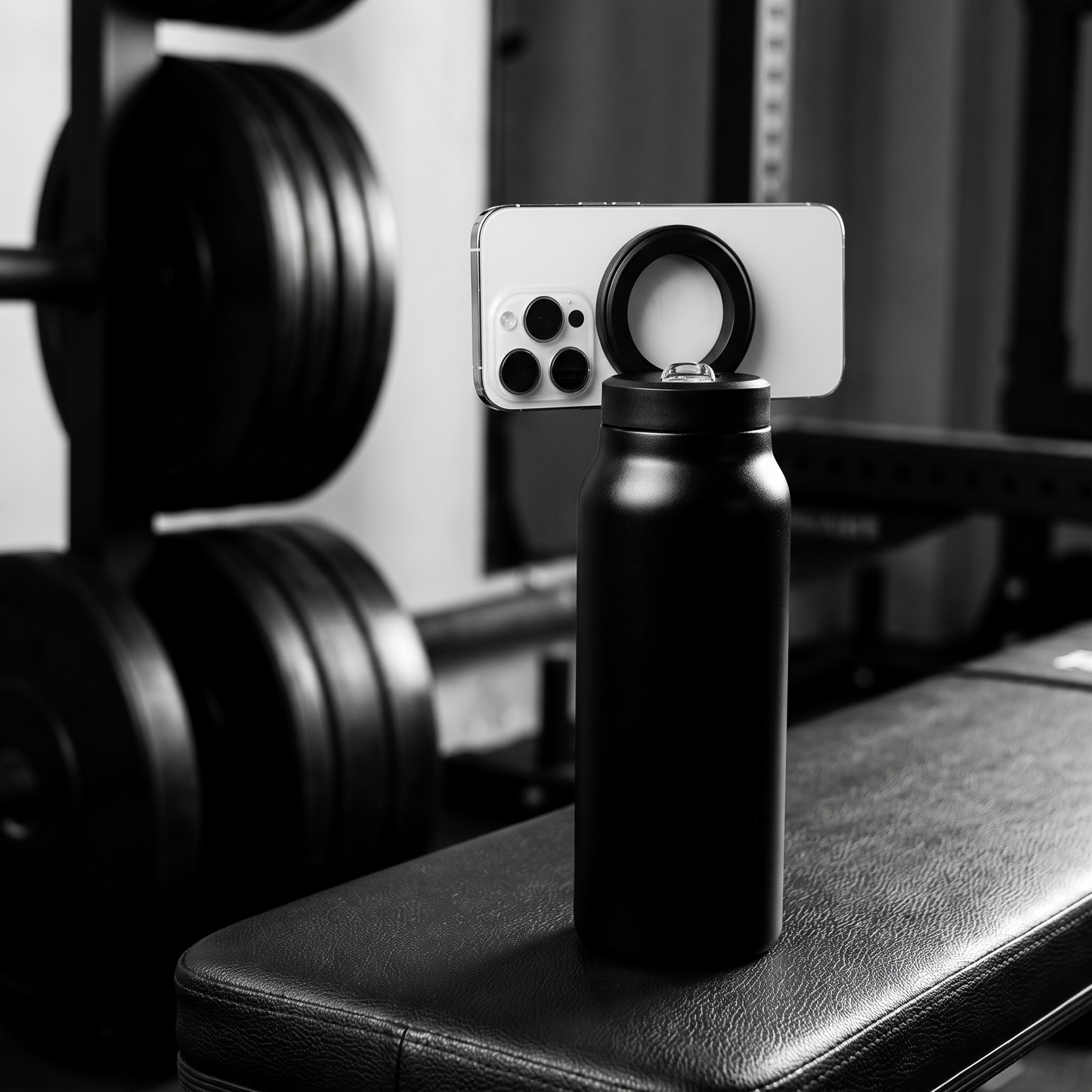 Bottle with phone mounted on the magnetic ring, filming on a gym bench